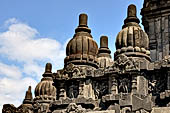 Prambanan - Candi Lara Jonggrang, miniature shrines surmounted by small fluted stupa with panels with musicians and dancers decorating the top of the balustrade 